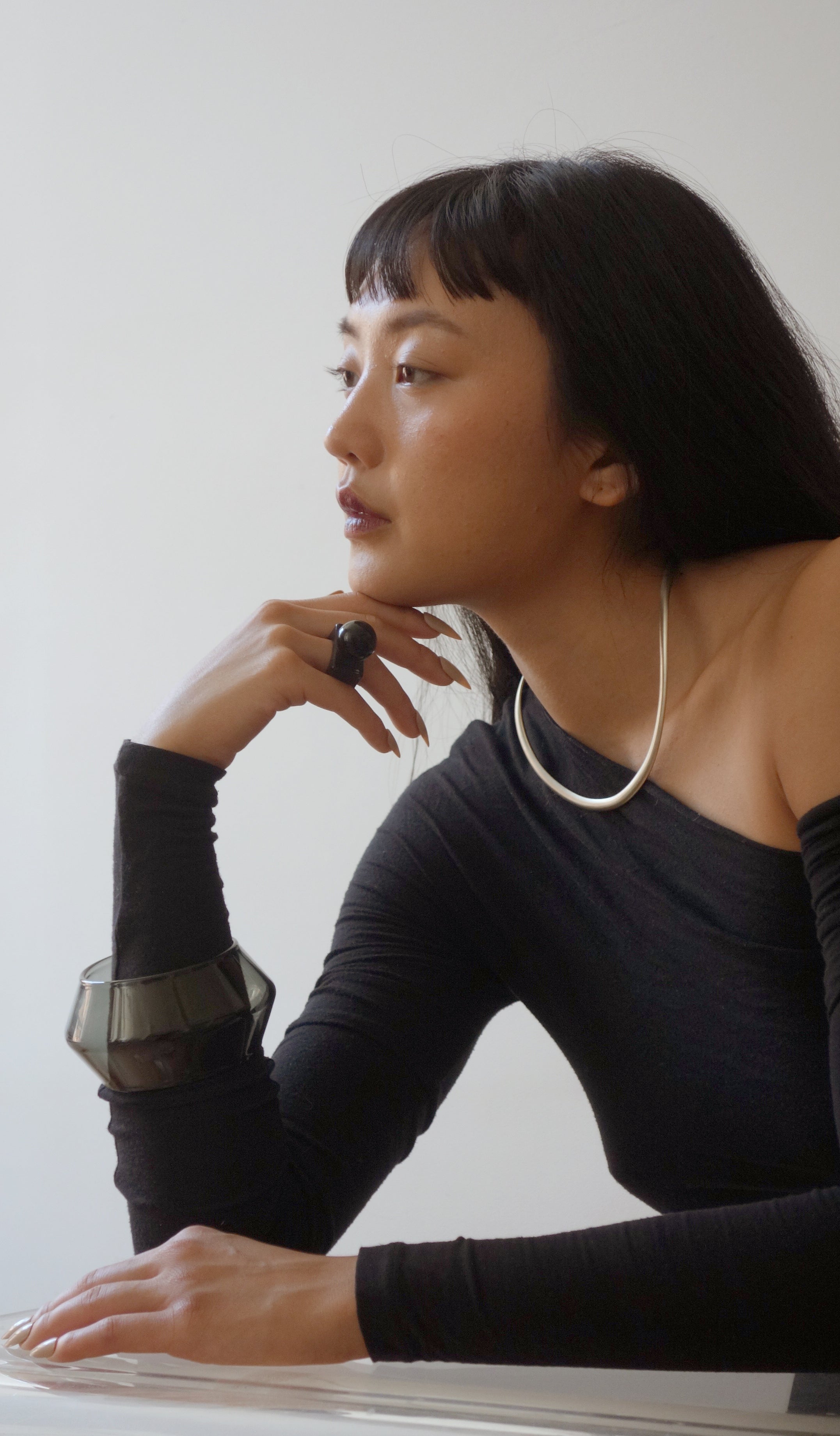 Woman wearing a black long-sleeve top with a white background