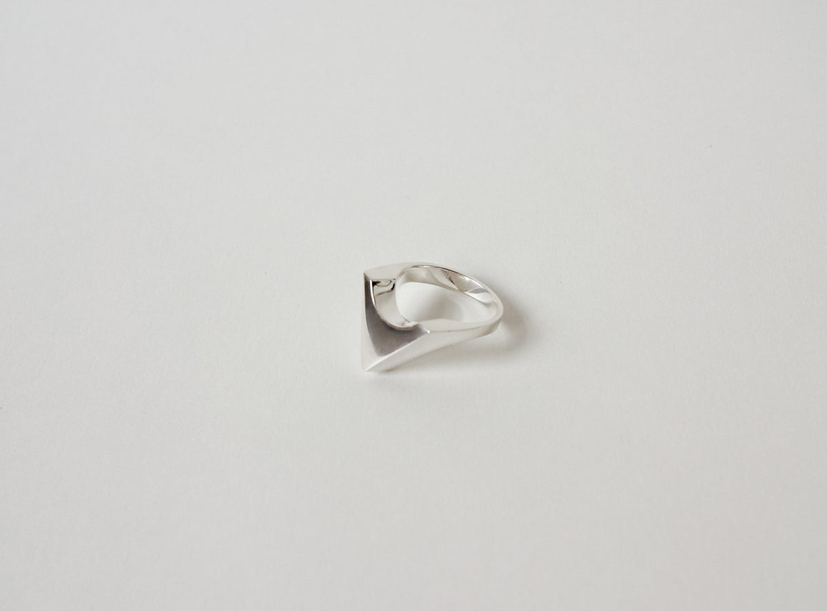 Silver ring with a unique design on a light gray background