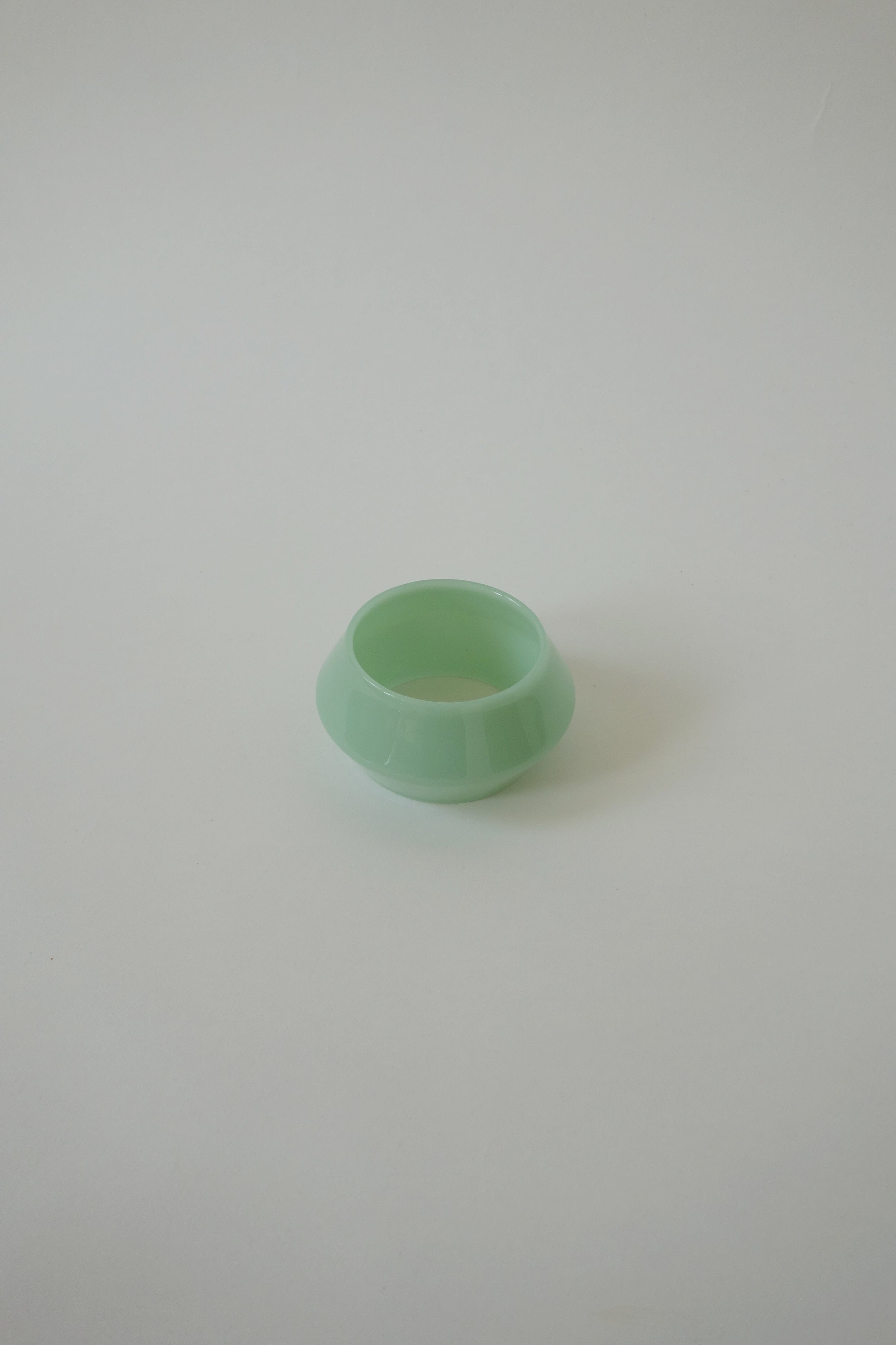 Green glass bracelet on a light gray background